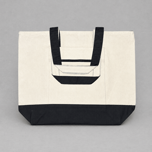 Impish Greetings heavy cotton canvas tote bag in cream with black handles, base, and front zipper pocket.