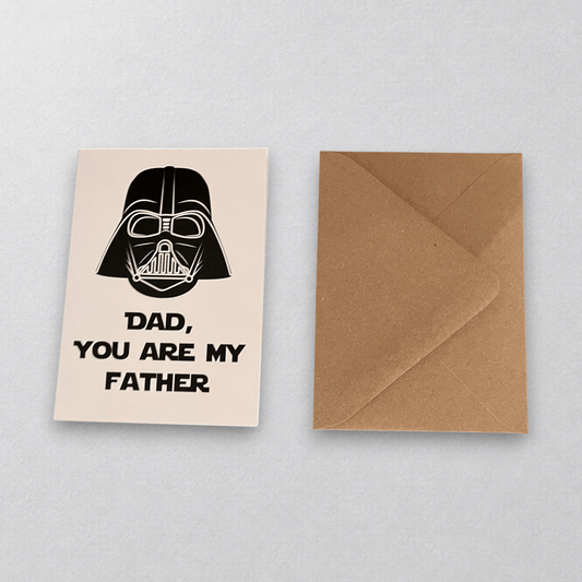 Impish Greetings Dad, You're My Father card featuring a Darth Vader illustration with a kraft envelope on wood table