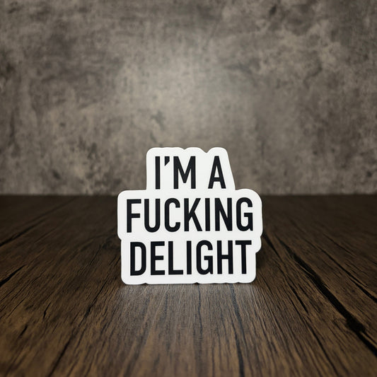 Impish Greetings matte vinyl sticker featuring the text I'm a Fucking Delight in bold black sans-serif font.
