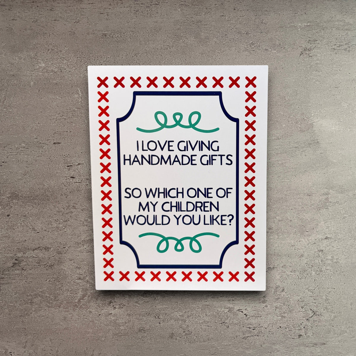 Impish Greetings handmade greeting card with funny text about giving away children, featuring red cross-stitch border