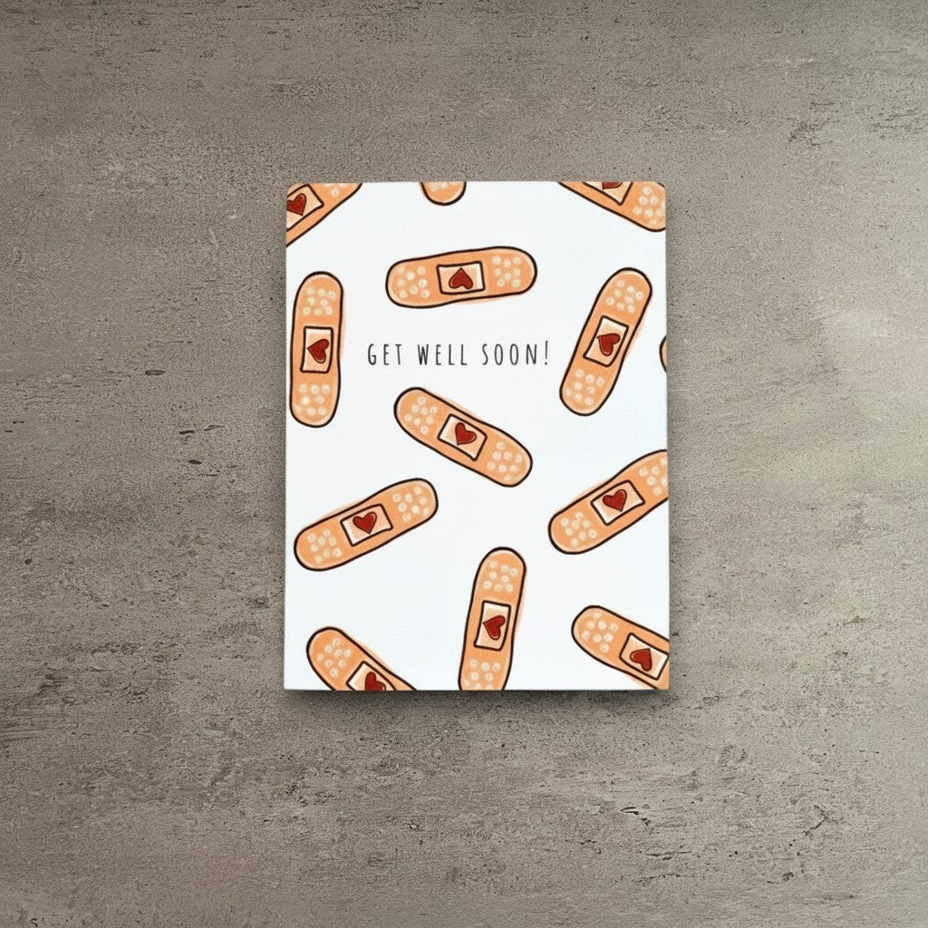 Impish Greetings Heart Bandaid get well soon greeting card with a pattern of adhesive bandages on white cardstock