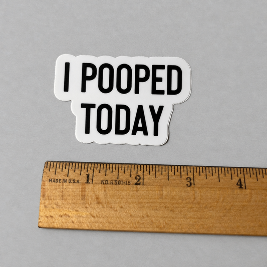 Impish Greetings I Pooped Today vinyl sticker with bold black text on a white background next to a wooden ruler.