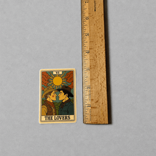 Impish Greetings The Lovers Tarot sticker featuring two cowboys in a matte vinyl finish next to a wooden ruler.