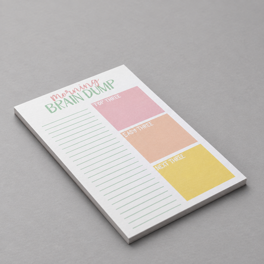 Impish Greetings Morning Brain Dump notepad with colorful task sections on sustainable paper against a grey background.