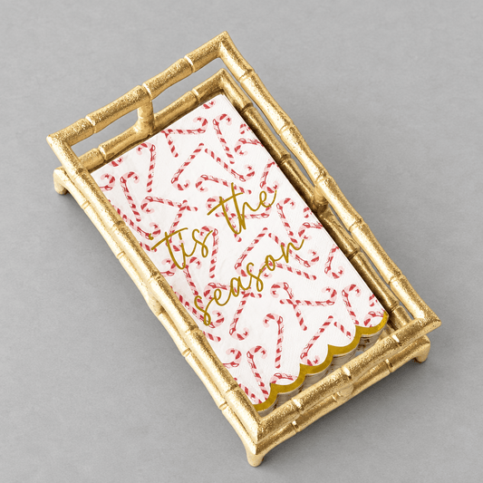 Impish Greetings Peppermint Toile paper guest towels with candy cane print and gold foil text in a gold bamboo tray.