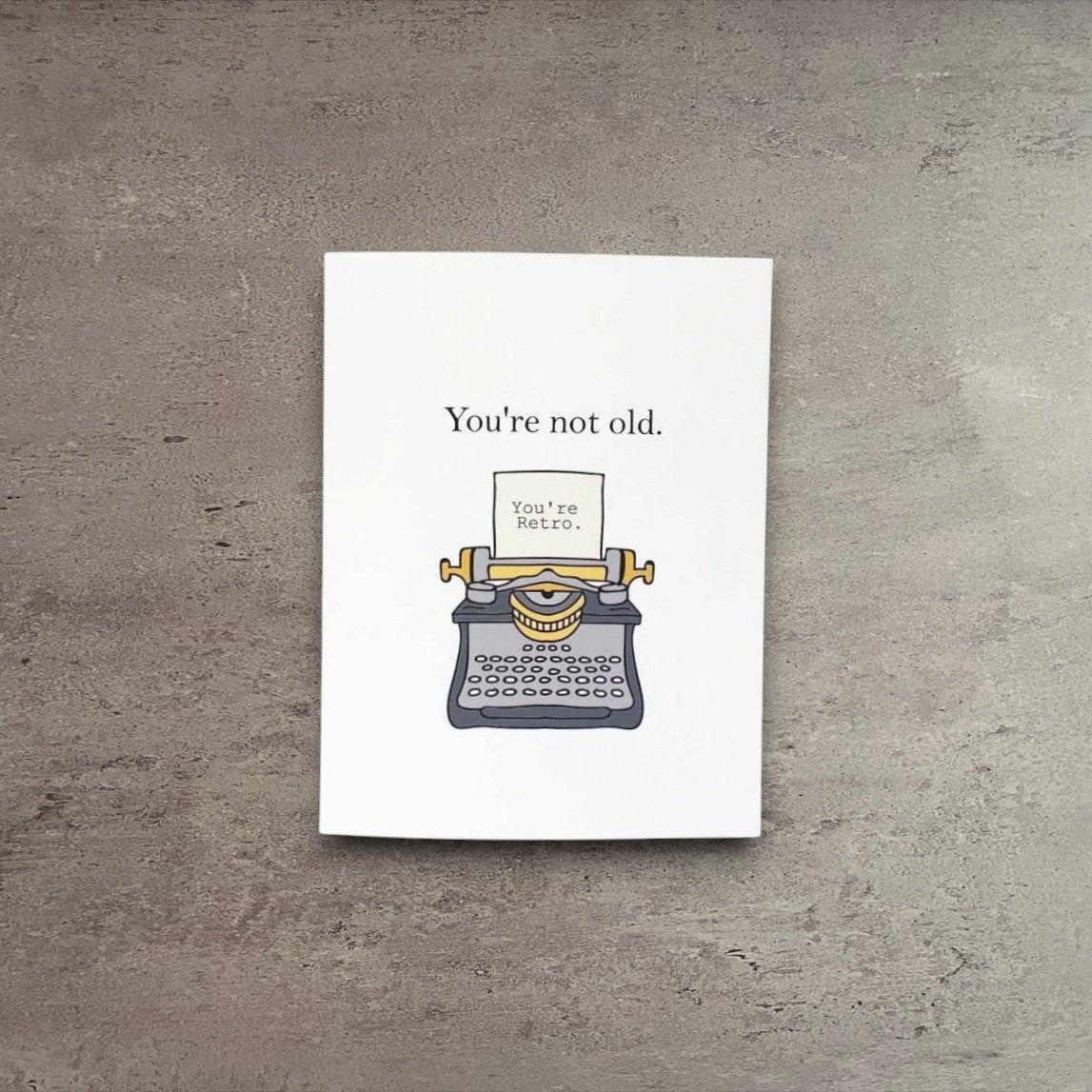 Impish Greetings retro birthday card featuring a vintage typewriter illustration on a white background