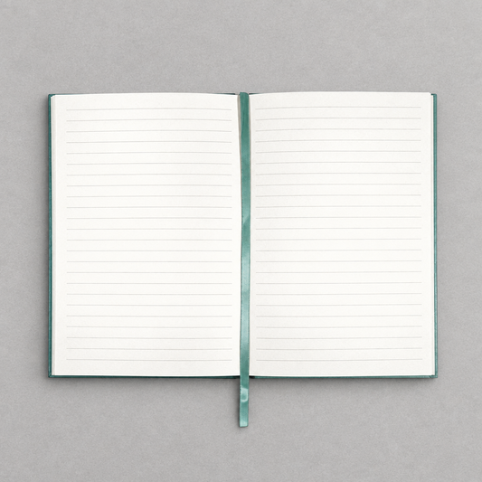 Impish Greetings A5 vintage notebook open to ivory lined pages with a matching teal ribbon bookmark