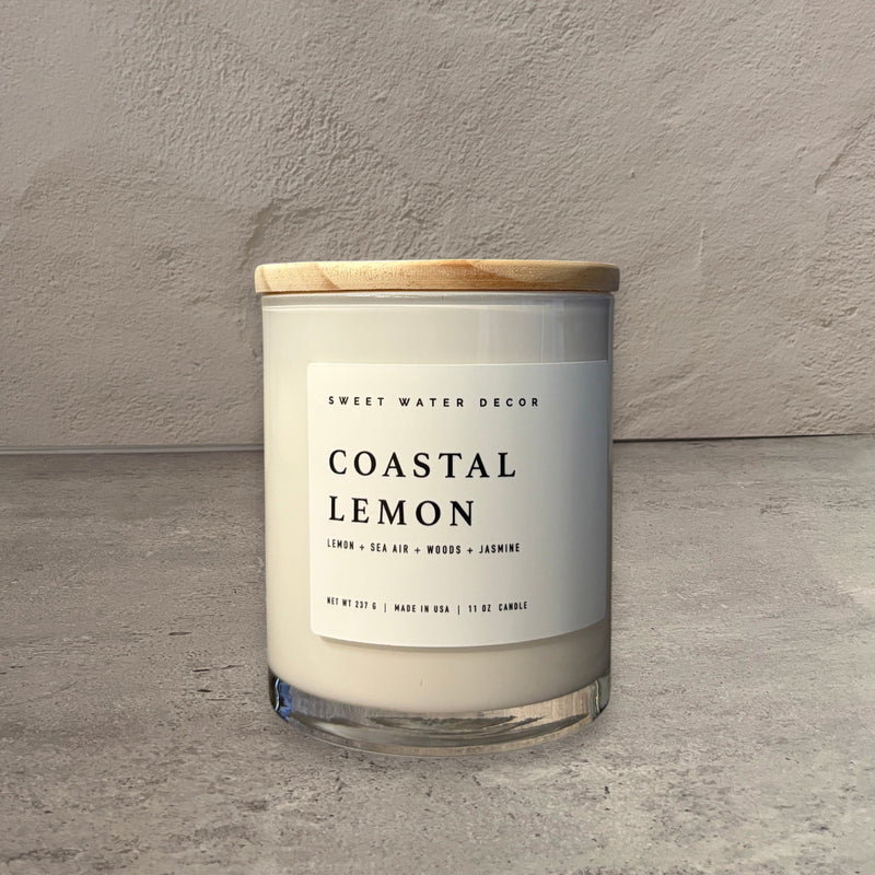 Impish Greetings 11 oz Coastal Lemon soy candle in a glass jar with a wooden lid on a grey surface