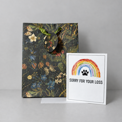 This shows the sorry for your loss condolence card against a grey background with a floral gift bag.