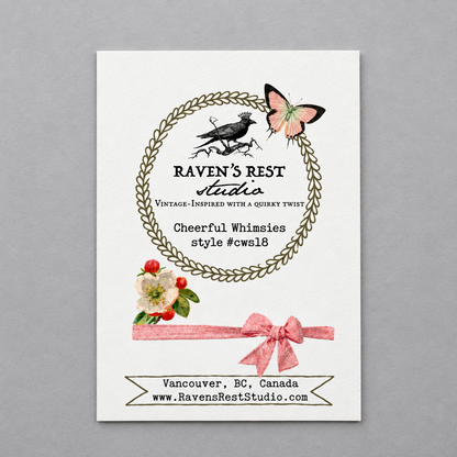 A vertical white art print or card centered on a gray background, featuring decorative vintage-style illustrations and text. The design includes a circular leaf wreath, a black bird, a pink butterfly, floral accents, and a pink ribbon bow, with the visible brand/title 'Raven's Rest Studio' and website text at the bottom.