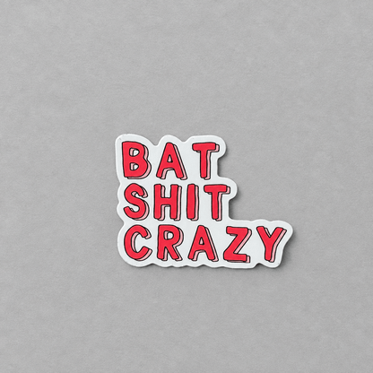 A die-cut vinyl sticker with the phrase 'BAT SHIT CRAZY' in bold red letters outlined in black, set against a light gray background.