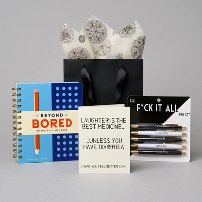 Feel Better, Dammit Gift Kit with plain black ribbon-handle bag and patterned tissue on muted light grey