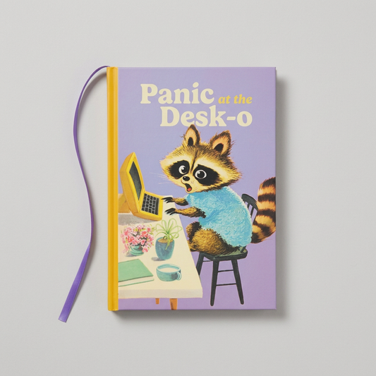Alternate flat lay of Panic at the Desk-o notebook with ribbon on muted light grey background