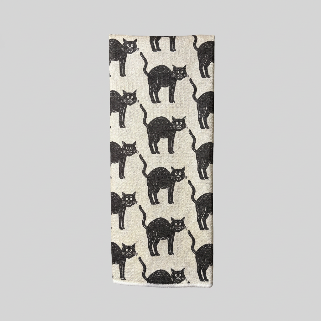 Front view of hanging black cat tea towel on muted light grey background