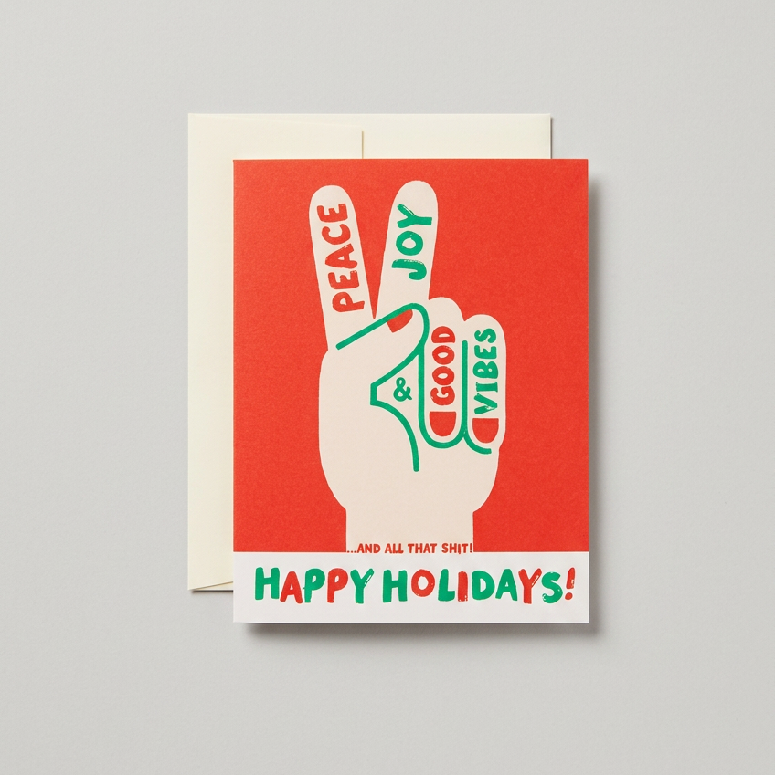 Holiday greeting card and cream envelope on a muted light grey background