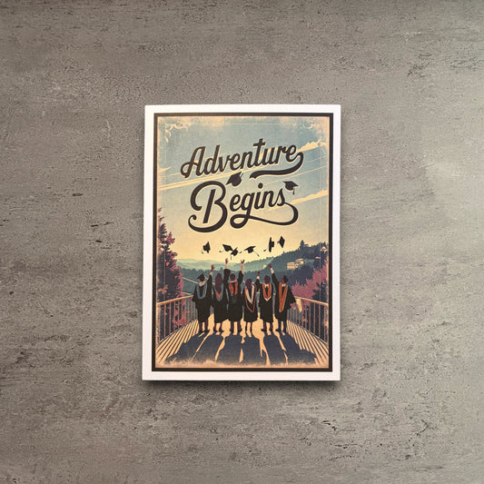 Impish Greetings graduation card featuring graduates on a bridge with the text Adventure Begins and a kraft envelope.