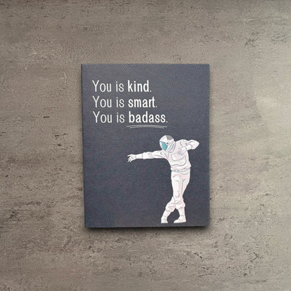 Impish Greetings You is Badass greeting card with an astronaut illustration on dark grey felt weave paper