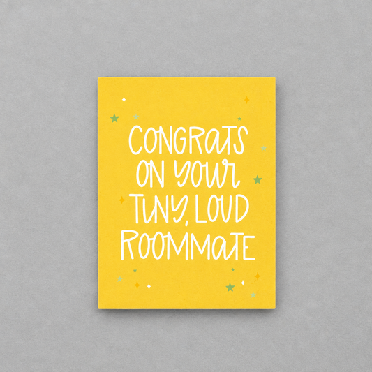 Impish Greetings baby congratulations card with yellow background and white text reading Congrats on Your Tiny Loud Roommate