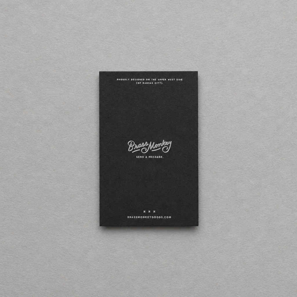 Impish Greetings Grown-ass Person memo pad with a black cover and white minimalist typography on a grey background.