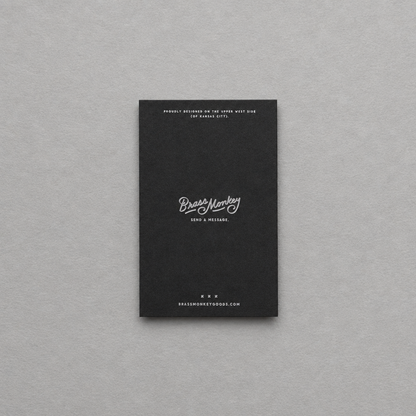 Impish Greetings Grown-ass Person memo pad with a black cover and white minimalist typography on a grey background.