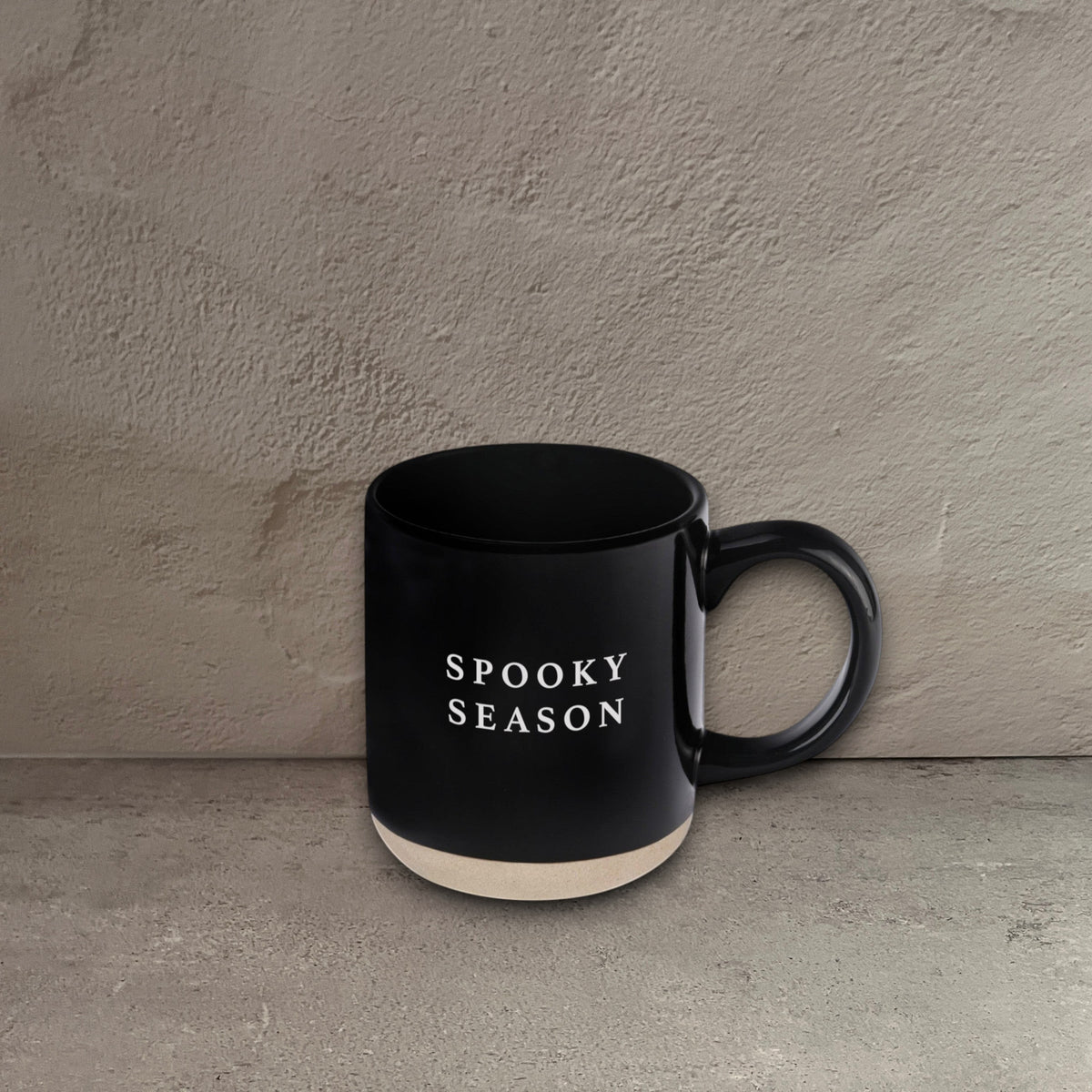 Impish Greetings black stoneware coffee mug with Spooky Season text in white, featuring a natural base.