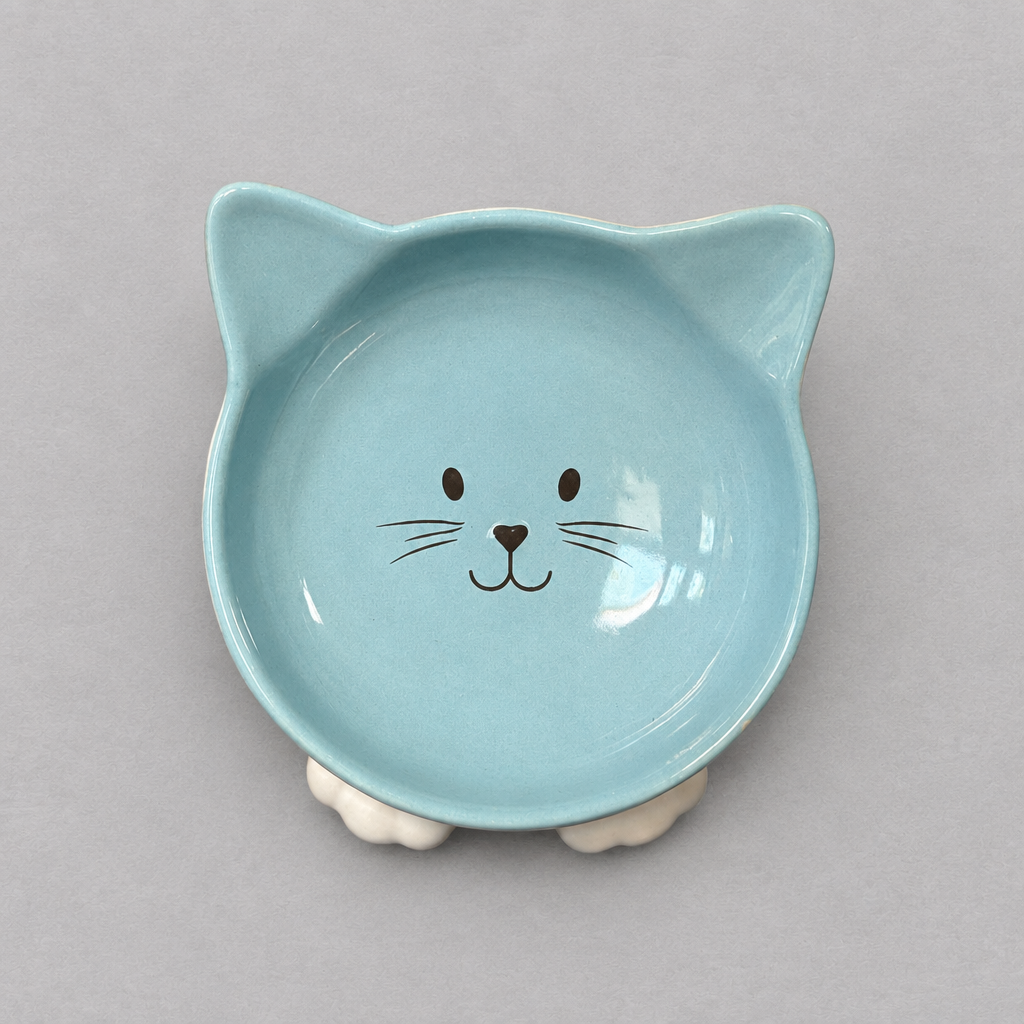 Impish Greetings blue ceramic cat-shaped bowl with a cute face design and tilted base for improved pet posture.