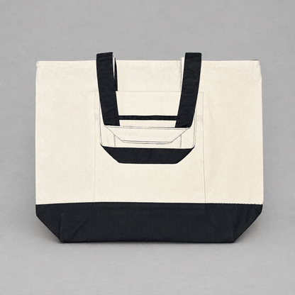 Impish Greetings heavy cotton canvas tote bag in cream with black handles, base, and front zipper pocket.