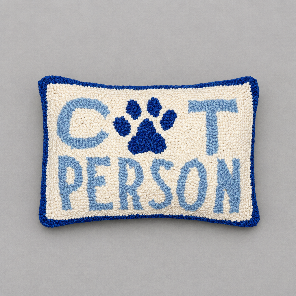 Impish Greetings Cat Person hook pillow in cream and blue wool with a paw print design on a grey background.