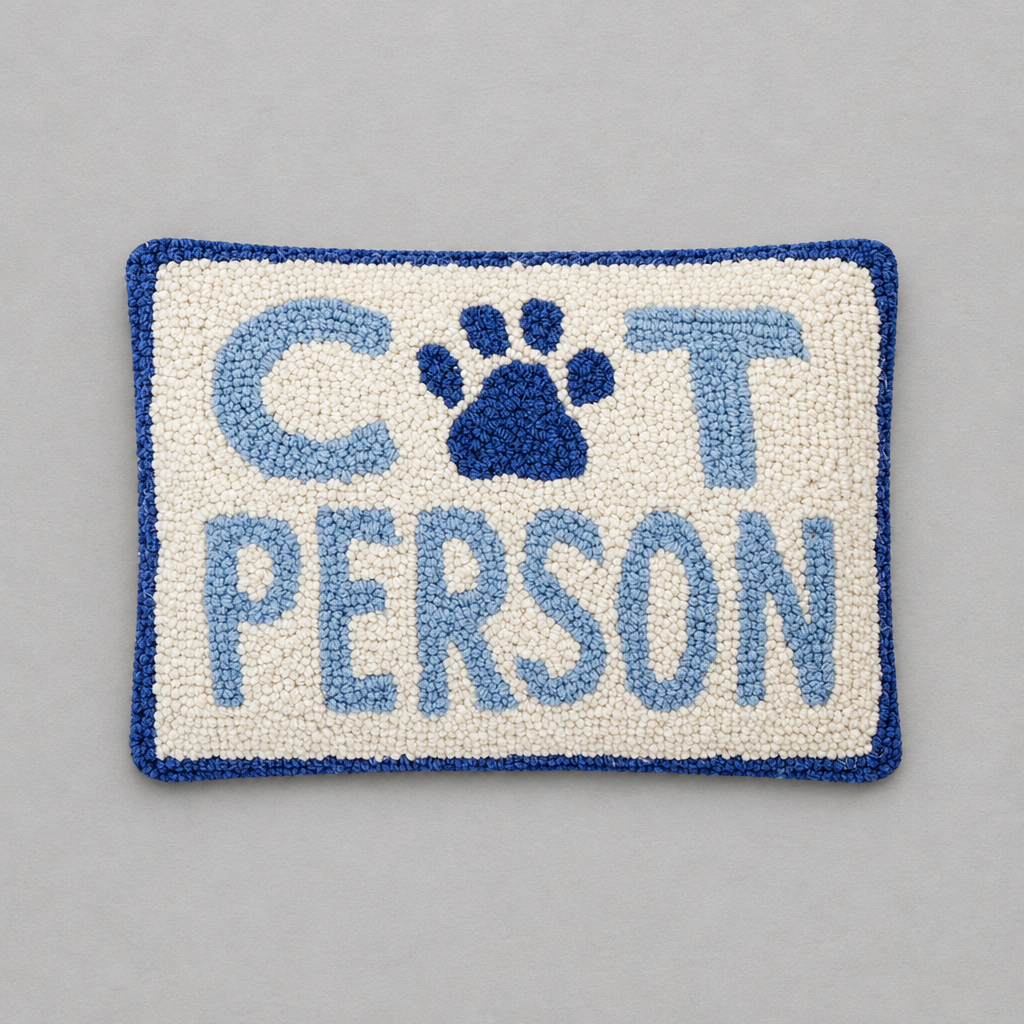 Impish Greetings Cat Person hook pillow in wool with blue and white text and a paw print design on a grey background.