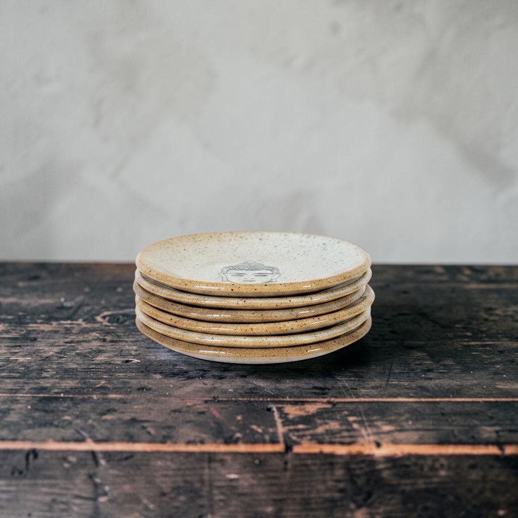 Impish Greetings handcrafted ceramic mini Buddha plate stack in speckled beige stoneware on a rustic wooden table