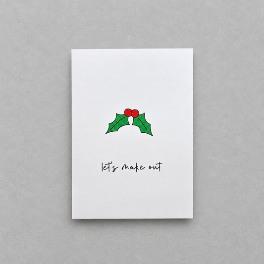 Impish Greetings Christmas card with holly illustration and the text Let's make out on white matte card stock
