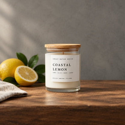 Impish Greetings Coastal Lemon soy candle in a glass jar with a wooden lid, set on a wooden table with fresh lemons.