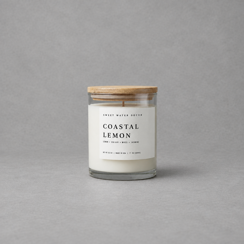 Impish Greetings Coastal Lemon soy candle in a glass jar with a wooden lid against a grey background.