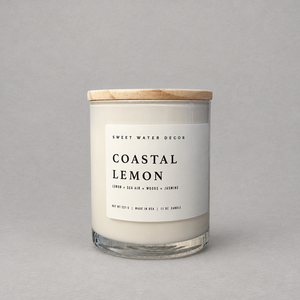 Impish Greetings Coastal Lemon 11 oz soy candle in a glass jar with a wooden lid against a grey background.