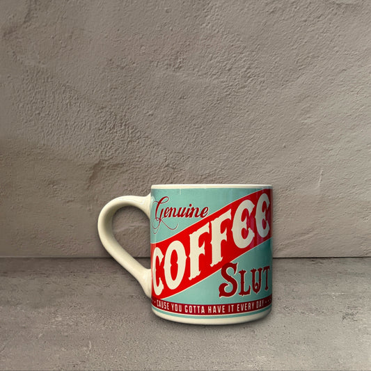 Impish Greetings 12 oz porcelain mug with vintage-style teal and red Coffee Slut typography on a grey background