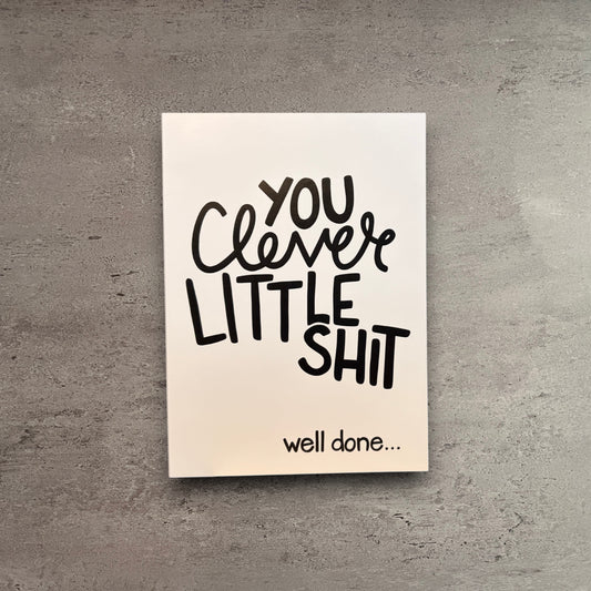 Impish Greetings Clever Little Shit congratulations card with black typography on white matte cardstock and kraft envelope