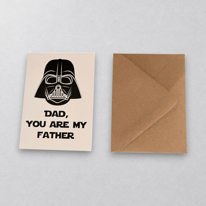 Impish Greetings Dad, You're My Father card featuring a Darth Vader illustration with a kraft envelope on wood table