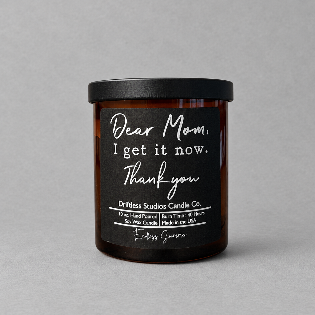 Impish Greetings Dear Mom I Get It Now soy wax candle in an amber glass jar with a black lid and minimalist label.