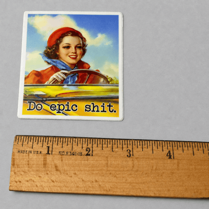 Impish Greetings Do Epic Shit vinyl sticker featuring a vintage-style woman driving a yellow car with matte finish.