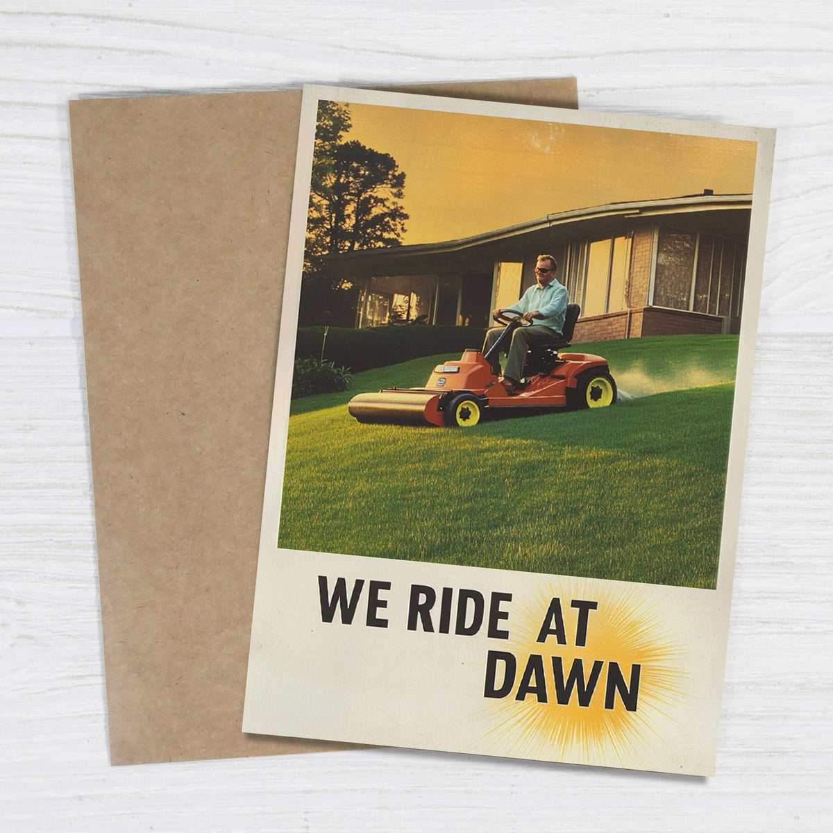 Impish Greetings We Ride At Dawn Father's Day card featuring a vintage lawn mower illustration and kraft envelope.