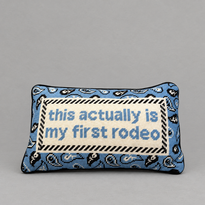 Impish Greetings First Rodeo needlepoint pillow with blue paisley pattern and witty text on a grey background