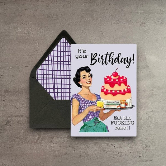 Birthday card featuring a vintage housewife illustration with a cake and funny text on a wood table.