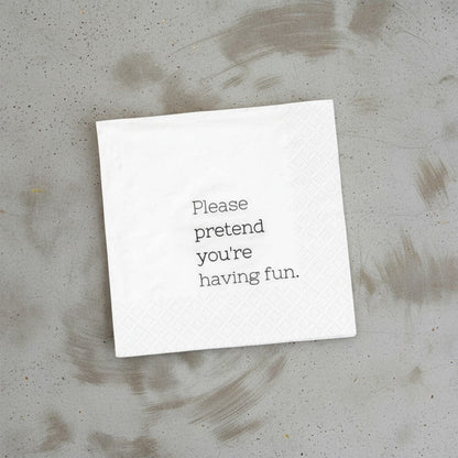 Impish Greetings white 3-ply cocktail napkin with the text Please pretend you're having fun printed in black