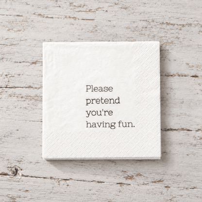 Impish Greetings white 3-ply cocktail napkin with the text Please pretend you're having fun printed in black