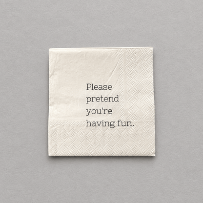 Impish Greetings cocktail napkin in cream 3-ply paper with the text Please pretend you're having fun printed in black