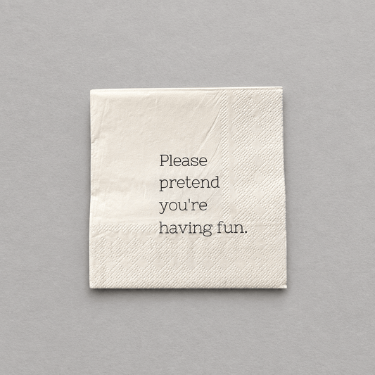 Impish Greetings cocktail napkin in cream 3-ply paper with the text Please pretend you're having fun printed in black
