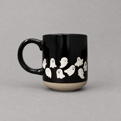 Impish Greetings black stoneware coffee mug with white ghost pattern and a natural clay base