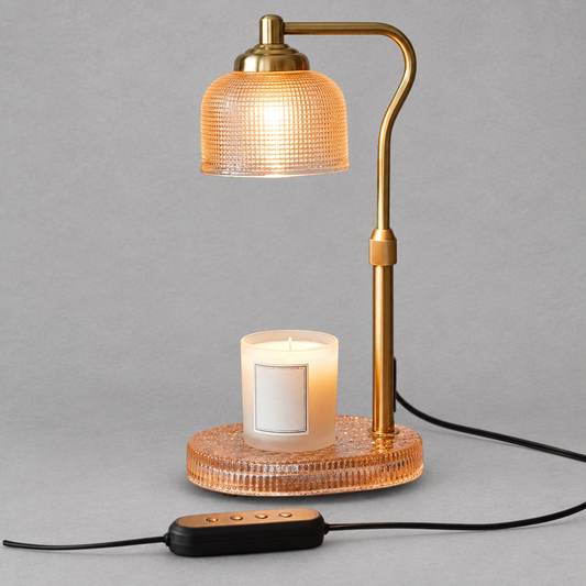 Impish Greetings candle lamp warmer with a gold metal stand, textured glass shade, and a scented candle on the base.