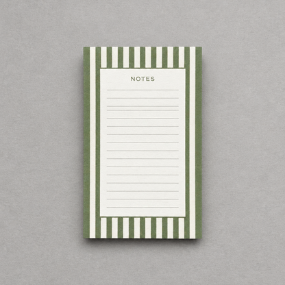 Impish Greetings green striped notepad with 75 lined tear-away pages for notes and to-do lists on a grey background.