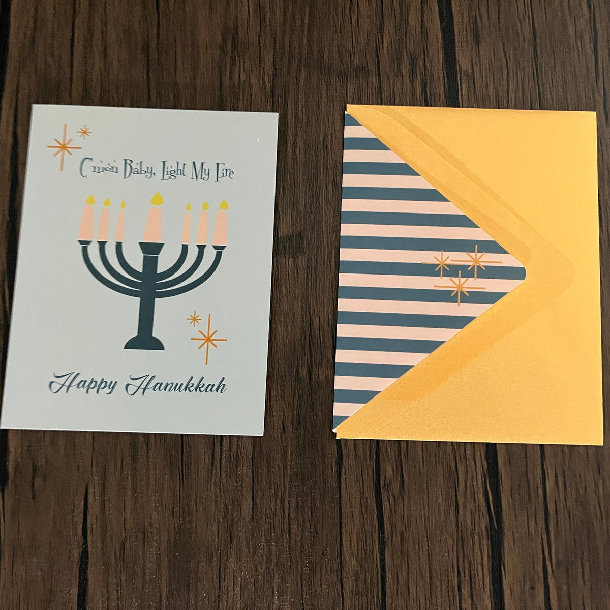 Impish Greetings Light My Fire Hanukkah card with mid-century menorah design and striped envelope liner